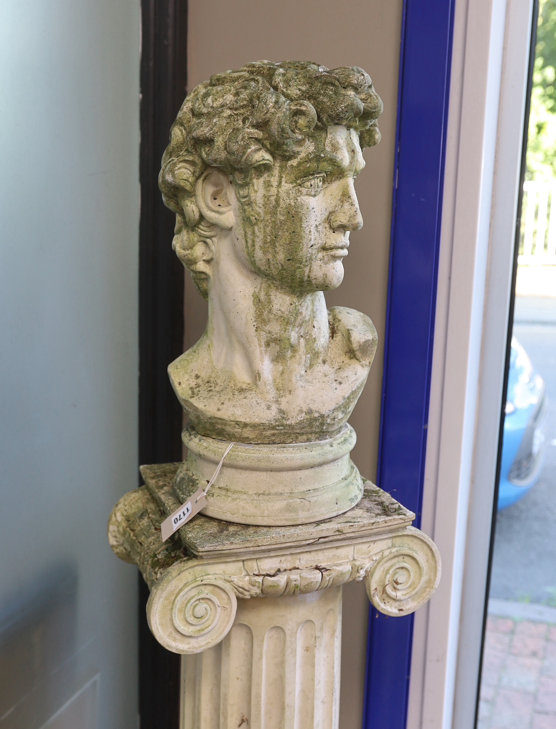 A reconstituted stone bust of David on ionic column pedestal, height 158cm